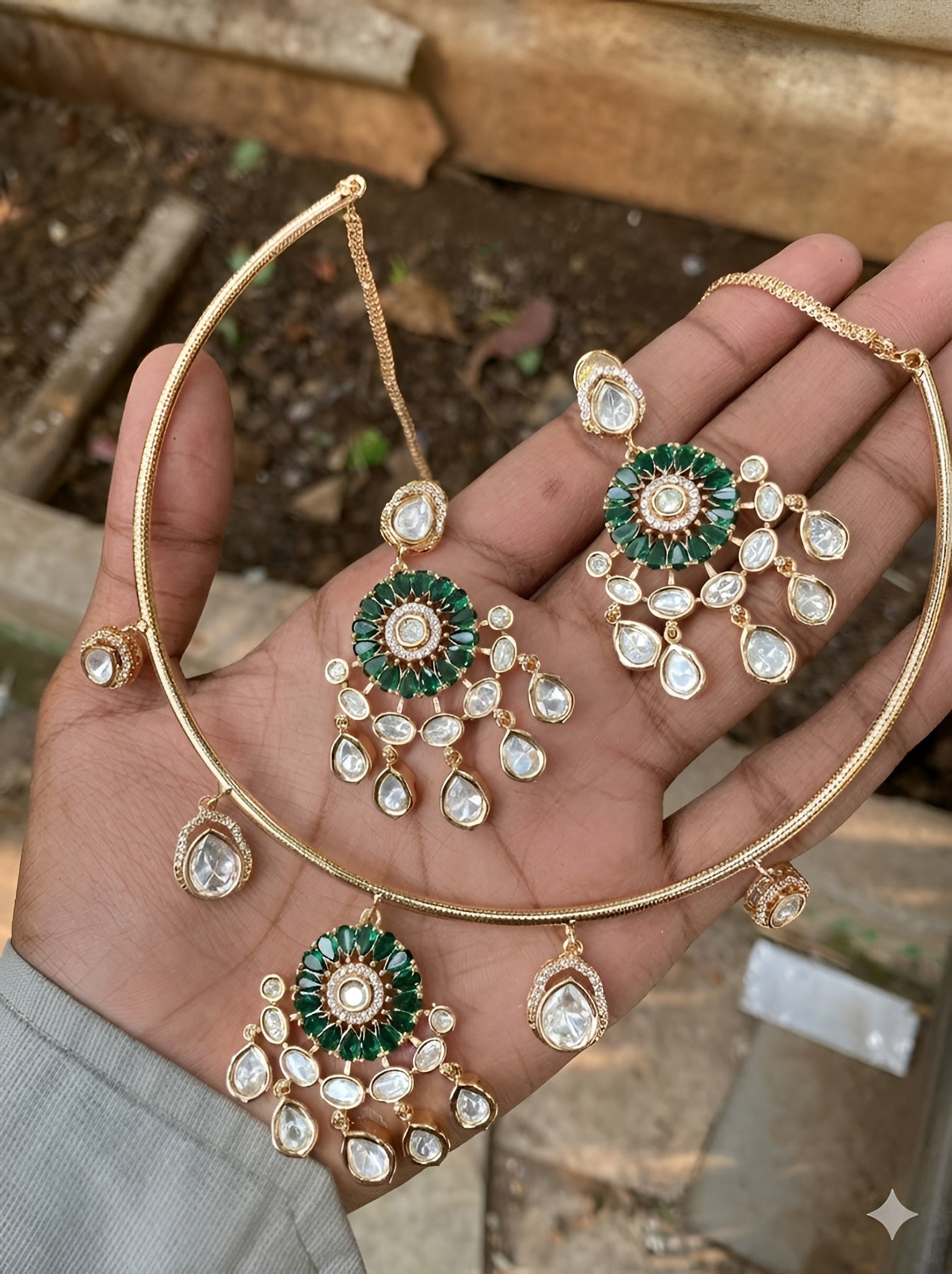Gold plated choker necklace set with green stones and kundan detailing, featuring matching earrings and teardrop hanging design