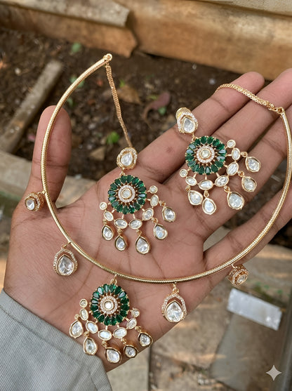 Gold plated choker necklace set with green stones and kundan detailing, featuring matching earrings and teardrop hanging design