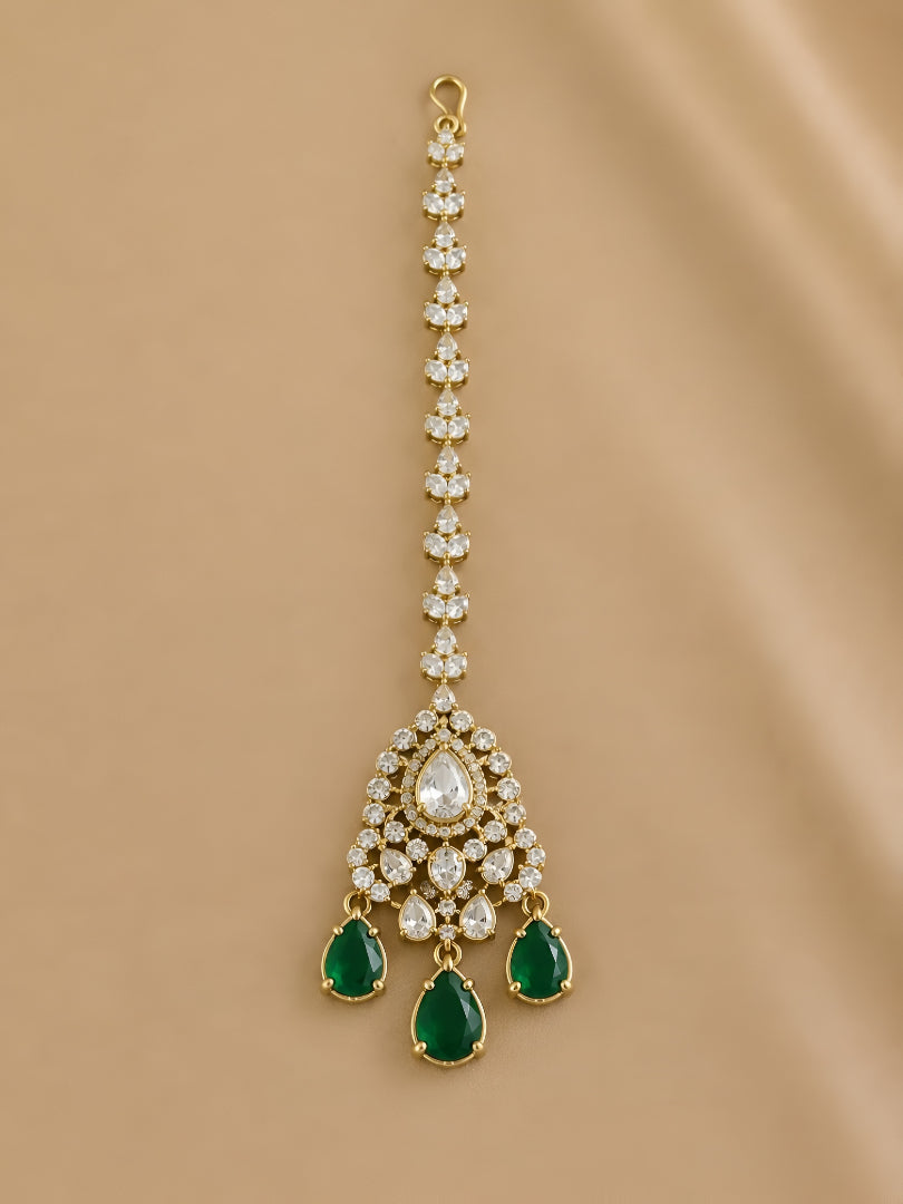 Gold triangle maang tikka with clear kundan stones and emerald green teardrop drops, Indian bridal hair jewelry on white background