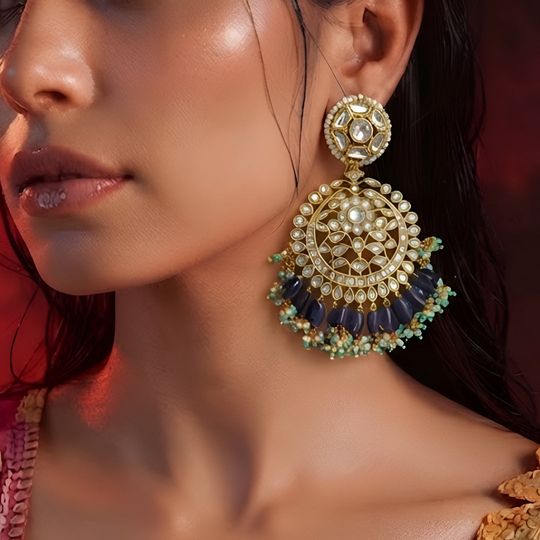 "Gold polish Kundan chandbali earrings with navy blue iolite beads and turquoise pearl fringe, displayed on jewelry stand"