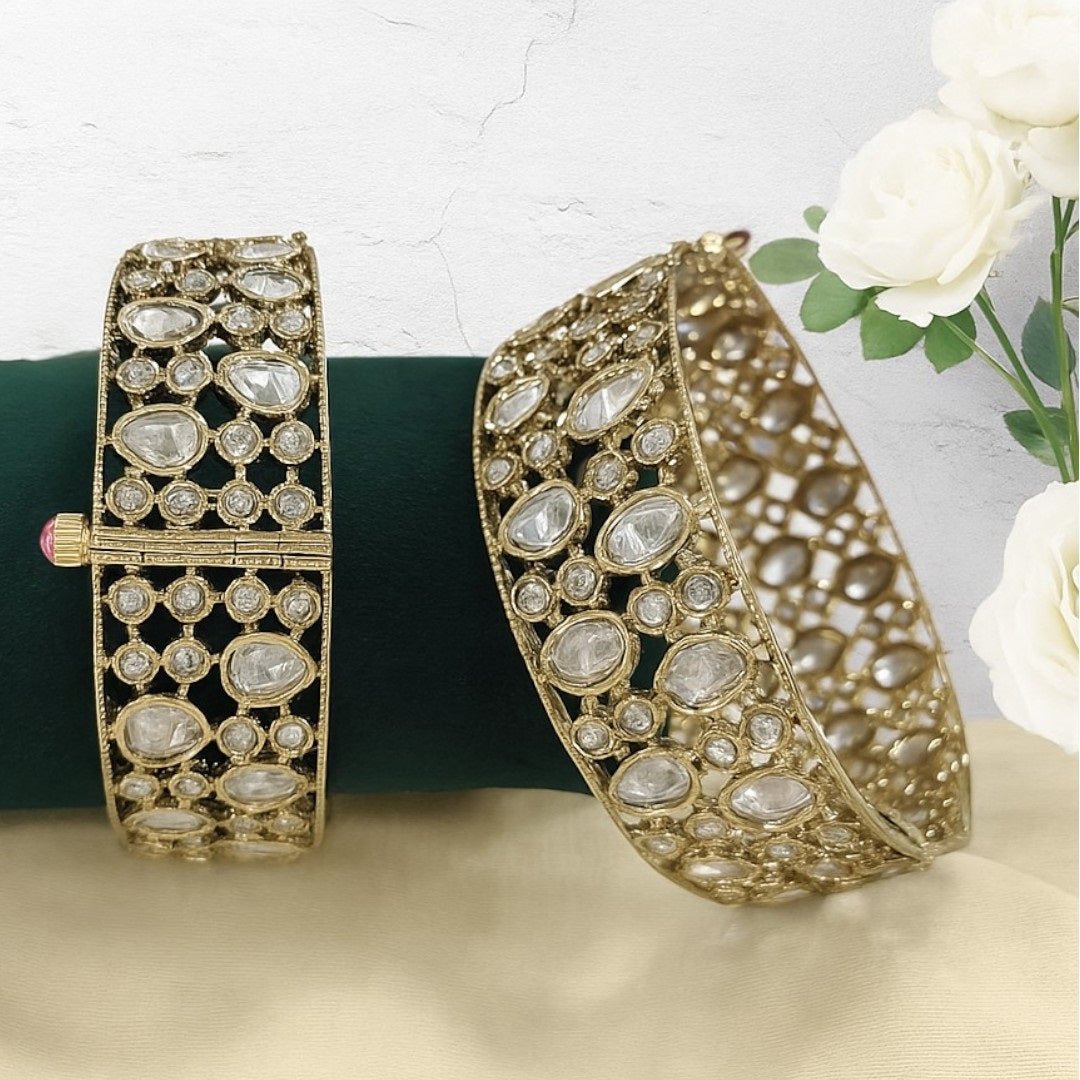 Elegant Kundan - Style Gold Plated Bangles with White Polki Stones - Auraa Trends - Bangles -  - Auraa Trends - Close - up of elegant gold - plated kundan - style bangles with white Polki stones, displayed on a dark green fabric roll – traditional Indian ethnic jewelry