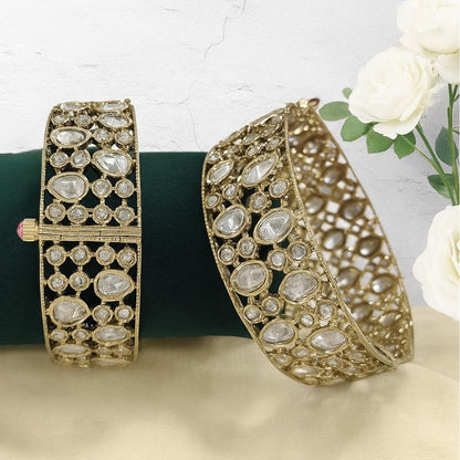 Elegant Kundan - Style Gold Plated Bangles with White Polki Stones - Auraa Trends - Bangles -  - Auraa Trends - Close - up of elegant gold - plated kundan - style bangles with white Polki stones, displayed on a dark green fabric roll – traditional Indian ethnic jewelry