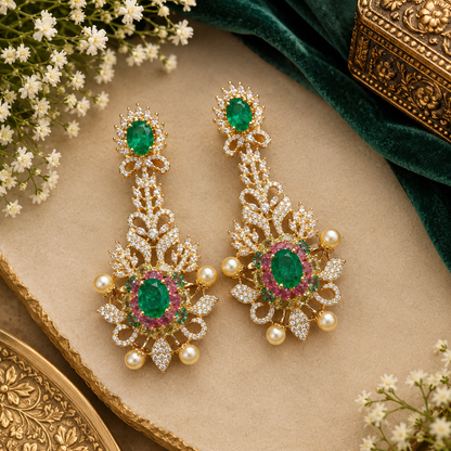 Rose gold plated emerald green American diamond long chandelier earrings with pink stones and pearl accents held in hand