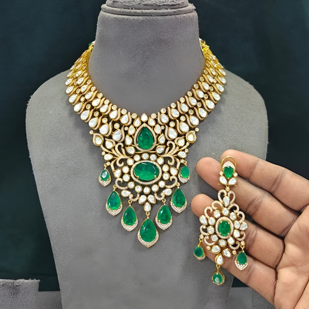 Gold kundan polki bridal necklace set with emerald green pear and oval stones, teardrop drops and matching chandelier earrings