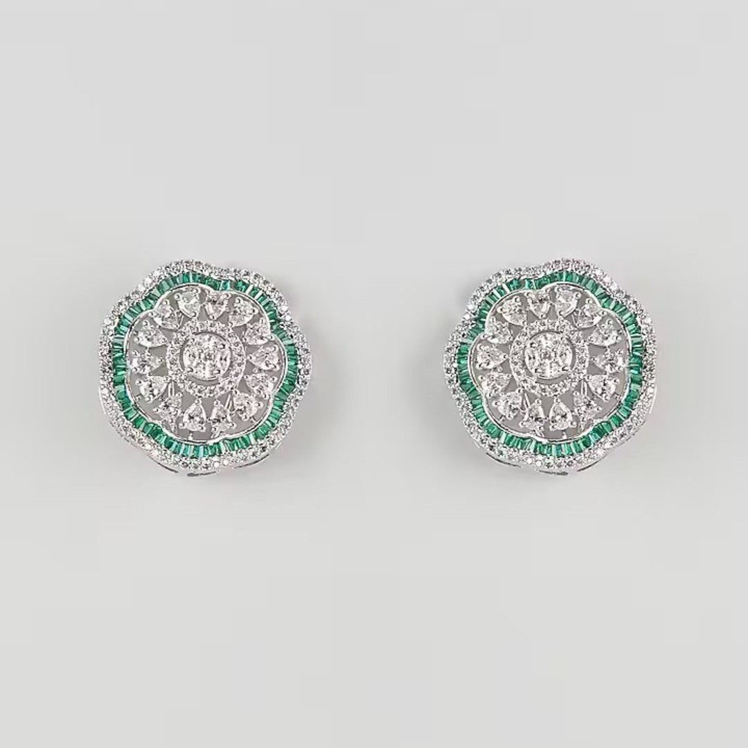 "Silver rhodium-plated floral stud earrings with white American diamonds and emerald green baguette stone halo"
