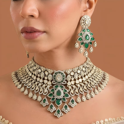 Gold-tone emerald green bridal choker necklace set with kundan-style stones, American diamond detailing, pear pendant cluster and chandelier earrings on dark green velvet
