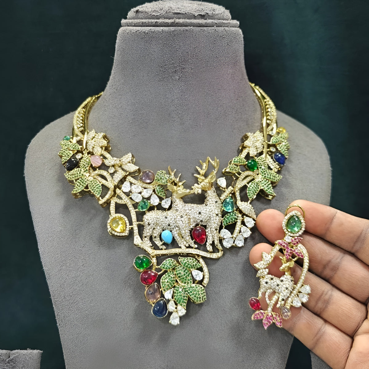 Gold plated deer motif statement necklace with zircon leaves and multicolour stones on a display bust