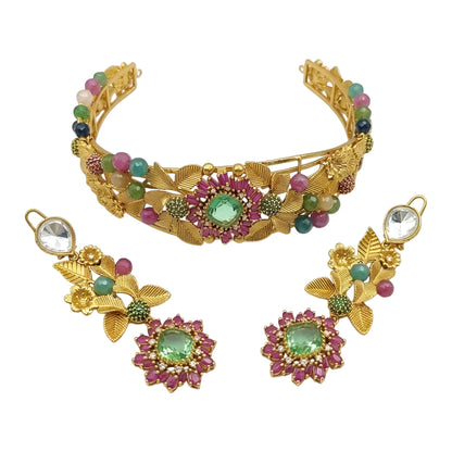 Antique gold rigid choker with leaf and flower design, ruby-pink baguette flower, mint-green centre stone and multicolour beads with matching drop earring on a grey display bust