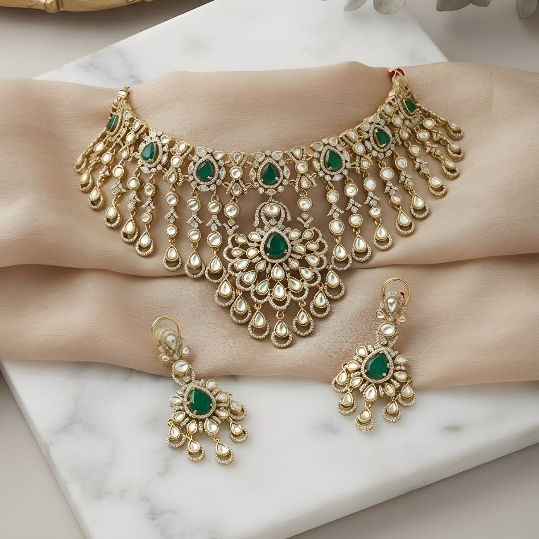 "Antique gold Kundan waterfall choker necklace with cascading fringe and emerald accents, matching chandelier drop earrings"