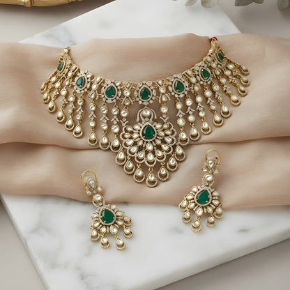"Antique gold Kundan waterfall choker necklace with cascading fringe and emerald accents, matching chandelier drop earrings"