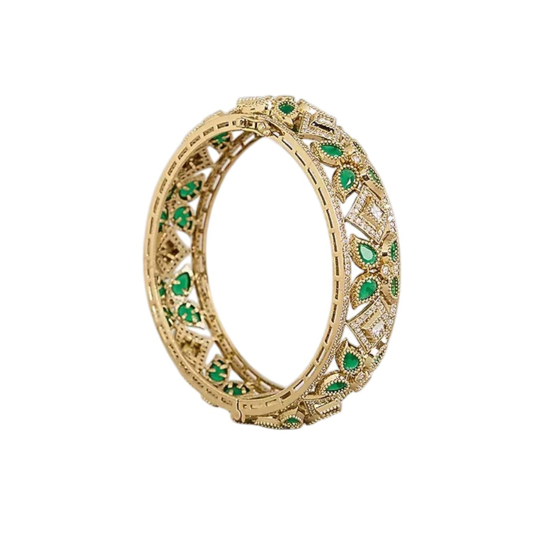 "Set of two gold-toned openwork bangles with emerald-green marquise stones and white CZ floral motifs, traditional Indian jewelry"