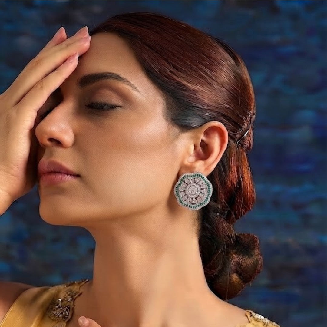 "Silver rhodium-plated floral stud earrings with white American diamonds and emerald green baguette stone halo"