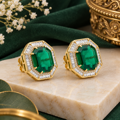 Pair of gold-finish octagon stud earrings with an emerald-green centre stone and a clear baguette-cut American diamond border