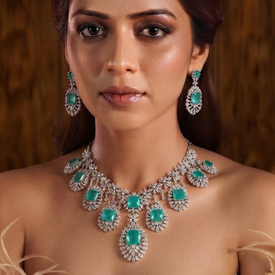 "Silver rhodium-plated multi-tier bridal necklace set with white American diamonds and cushion-cut emerald green stones, paired with matching drop earrings"