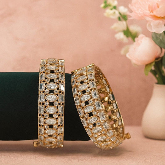 Gold - Plated Designer Bangles with Marquise & Emerald - Cut White CZ Stones - Auraa Trends - Bangles -  - Auraa Trends - Close - up of gold - plated bangles adorned with marquise, emerald - cut, and round white CZ stones, displayed on a velvet roll – elegant traditional jewelry for women