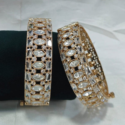 Gold - Plated Designer Bangles with Marquise & Emerald - Cut White CZ Stones - Auraa Trends - Bangles -  - Auraa Trends - Close - up of gold - plated bangles adorned with marquise, emerald - cut, and round white CZ stones, displayed on a velvet roll – elegant traditional jewelry for women