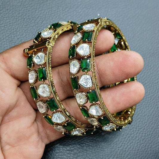 Gold - Plated Green & White Stone Studded Ethnic Bangles for Women - Auraa Trends - Bangles -  - Auraa Trends - Close - up view of gold - plated ethnic bangles with green and white stones on a yellow background