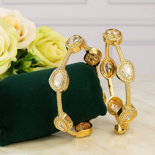 Gold - Plated Minimal Kundan - Style Open Bangles with White Stones - Auraa Trends - Bangles -  - Auraa Trends - Gold - plated minimalist bangles with large white uncut - style stones and textured finish, displayed with a floral decor backdrop