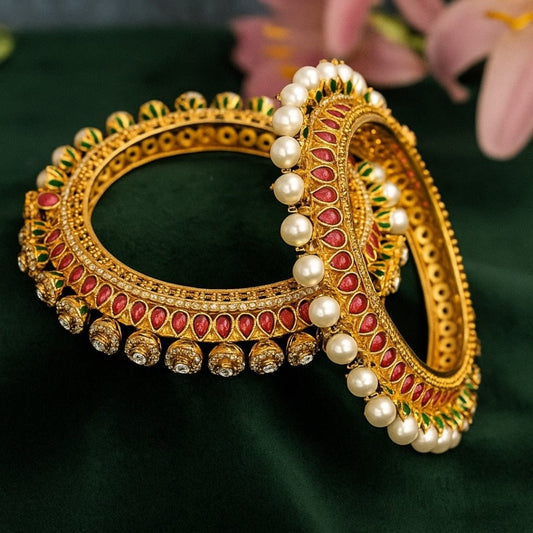 Gold - Plated Traditional Red Enamel Bangles with Pearl & Kundan Detailing - Auraa Trends - Bangles -  - Auraa Trends - “Traditional gold - plated bangles with red enamel, pearl beading, kundan stones, and green detailing – set of 2 on green velvet background.”
