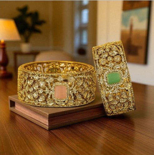 Gold - Plated Wide Kundan Bangles with Pastel Pink & Green Stones - Auraa Trends - Bangles -  - Auraa Trends - “Wide gold - plated kundan bangles with pastel pink and green center stones, traditional Indian bridal jewelry displayed on beige background.”