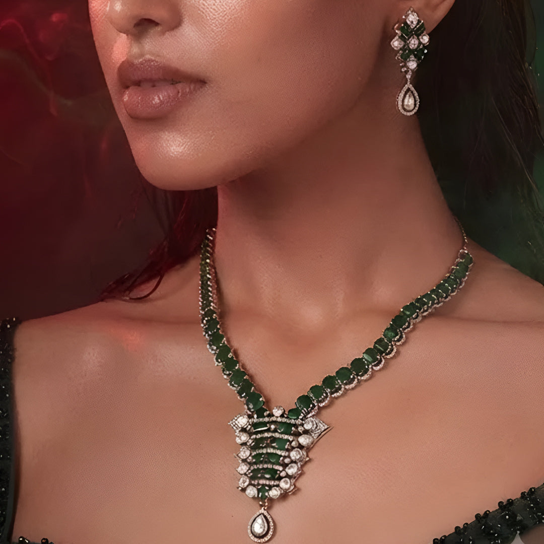 "Emerald green Kundan-style necklace and earring set with antique gold finish and white stone accents"