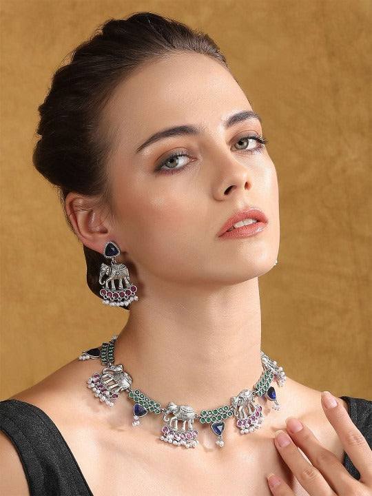 Oxidised silver-tone elephant motif necklace set with green, blue, and pink stones, pearl-style bead drops, and matching earrings