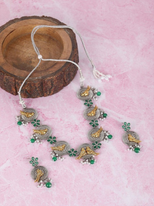 Oxidised silver-tone necklace set with gold-tone bird motifs, green enamel flowers, green bead drops, and matching earrings