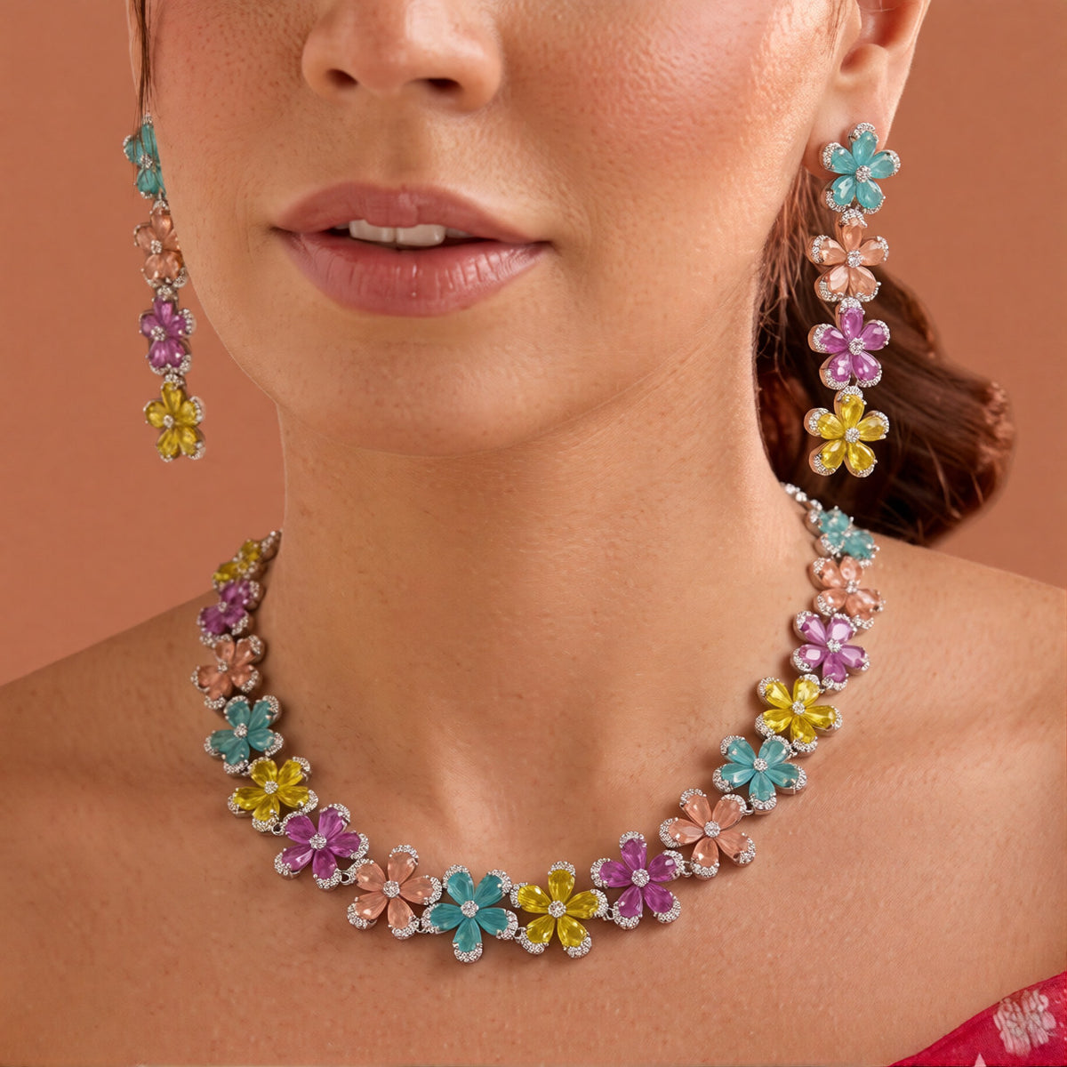 Silver plated multicolour flower American diamond necklace set with aqua, peach, pink and yellow stones and matching drop earrings on a marble slab