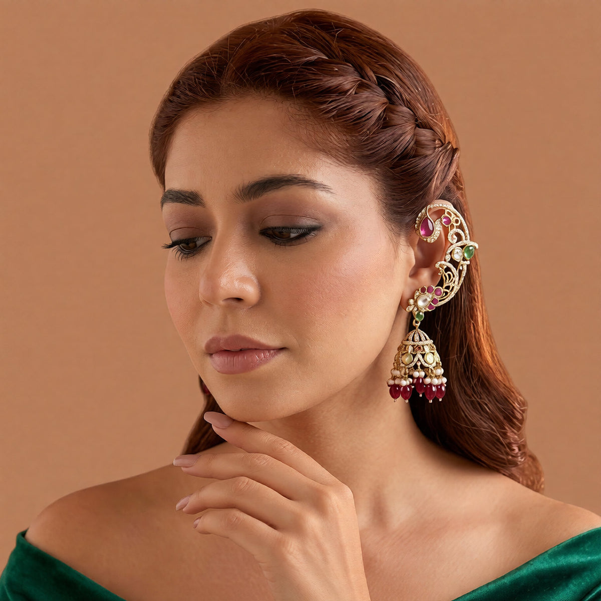 Gold plated ruby maroon ear cuff peacock jhumka earrings with American diamond stones, maroon beads and pearl hangings on a white background