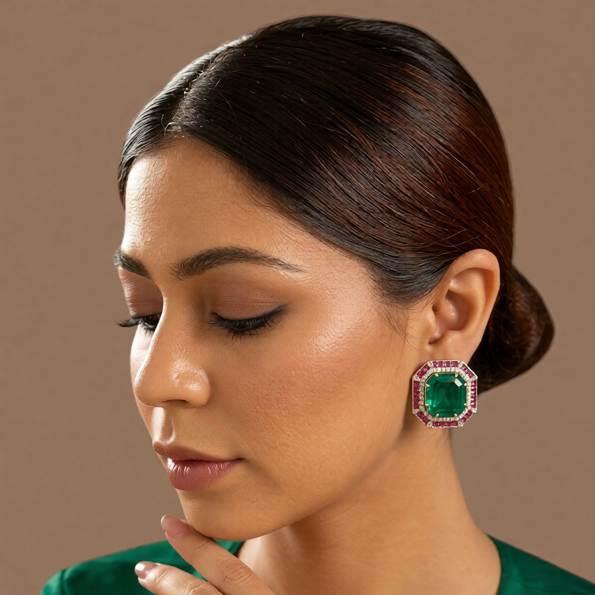 Pair of gold-finish octagon stud earrings with an emerald-green centre stone, ruby-pink square-cut border, and American diamond halo