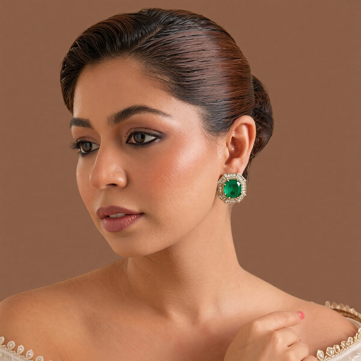 Pair of gold-finish octagon stud earrings with an emerald-green centre stone and a clear baguette-cut American diamond border