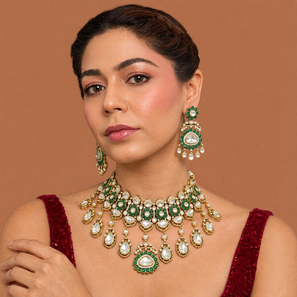 Antique gold Victorian kundan bridal choker with emerald-green flower medallions, pear-stone drops and a matching drop earring on a grey display bust
