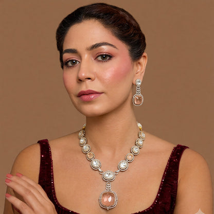Antique gold Victorian kundan necklace with a large square peach-pink pendant and matching drop earring on a grey display bust
