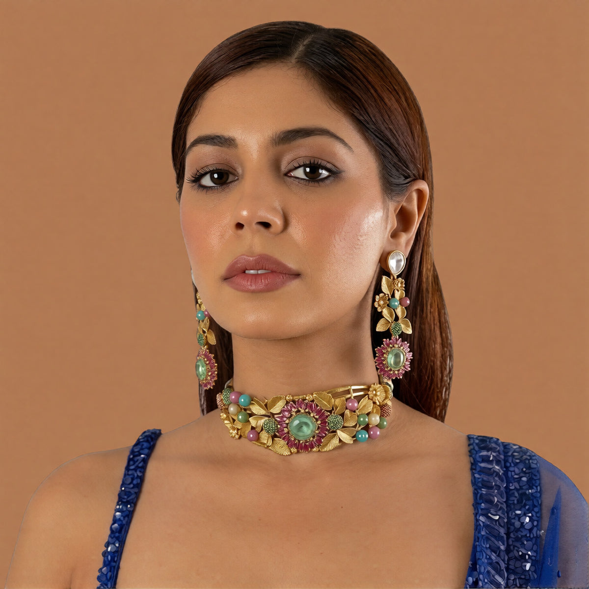 Antique gold rigid choker with leaf and flower design, ruby-pink baguette flower, mint-green centre stone and multicolour beads with matching drop earring on a grey display bust
