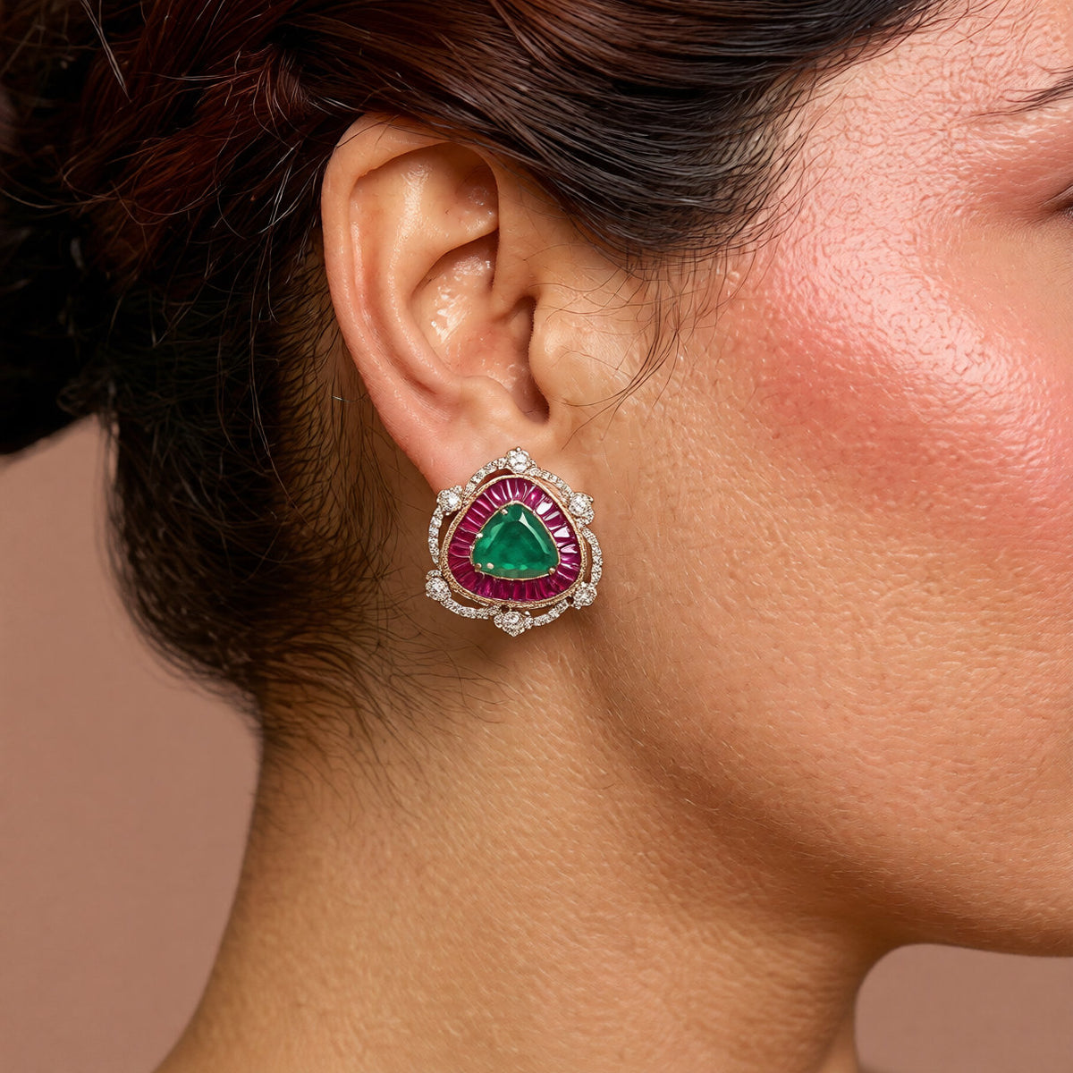 Pair of gold halo stud earrings with emerald-green triangle centre stones, ruby-pink baguette borders and zircon
