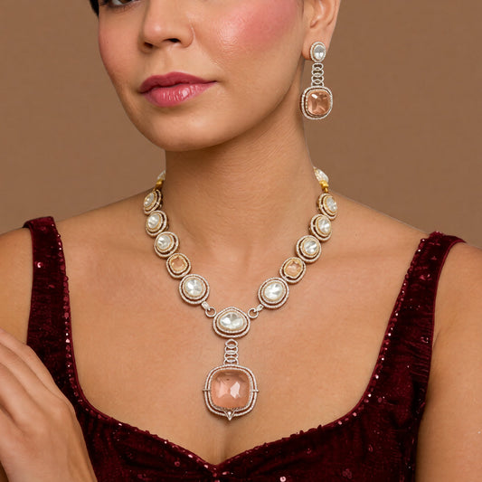 Antique gold Victorian kundan necklace with a large square peach-pink pendant and matching drop earring on a grey display bust