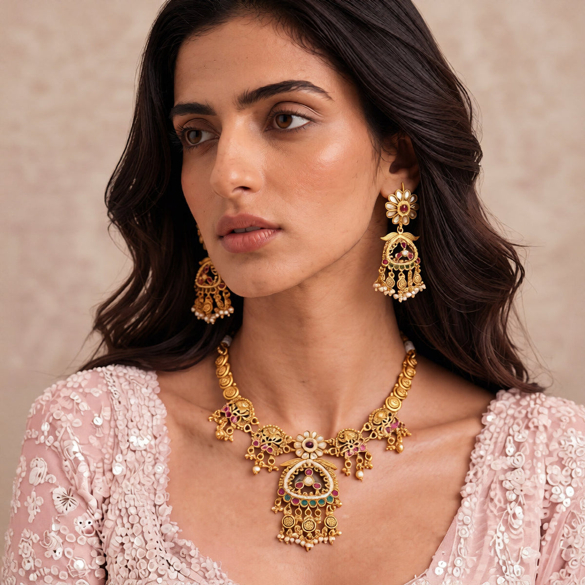Antique matte gold temple necklace set with green triangular pendant, ruby pink stones, pearl drops and matching chandelier earrings on teal bust
