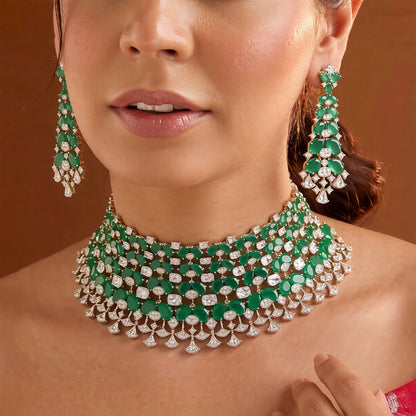 Emerald green American diamond choker necklace on a display bust with a matching long drop earring in hand