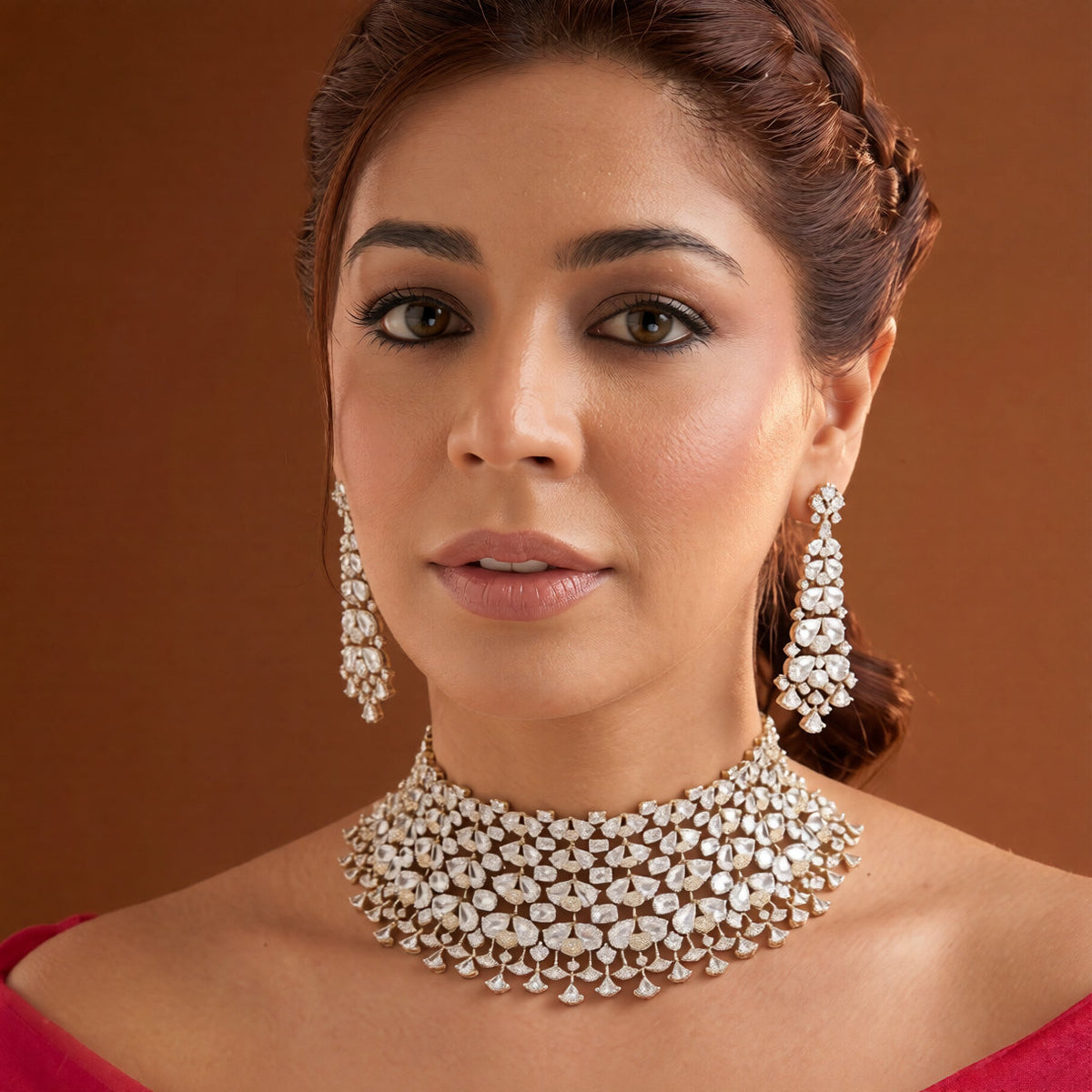 Gold finish American diamond bridal choker necklace on a display bust with a matching long drop earring in hand