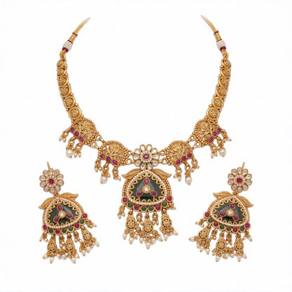 Antique matte gold temple necklace set with green triangular pendant, ruby pink stones, pearl drops and matching chandelier earrings on teal bust