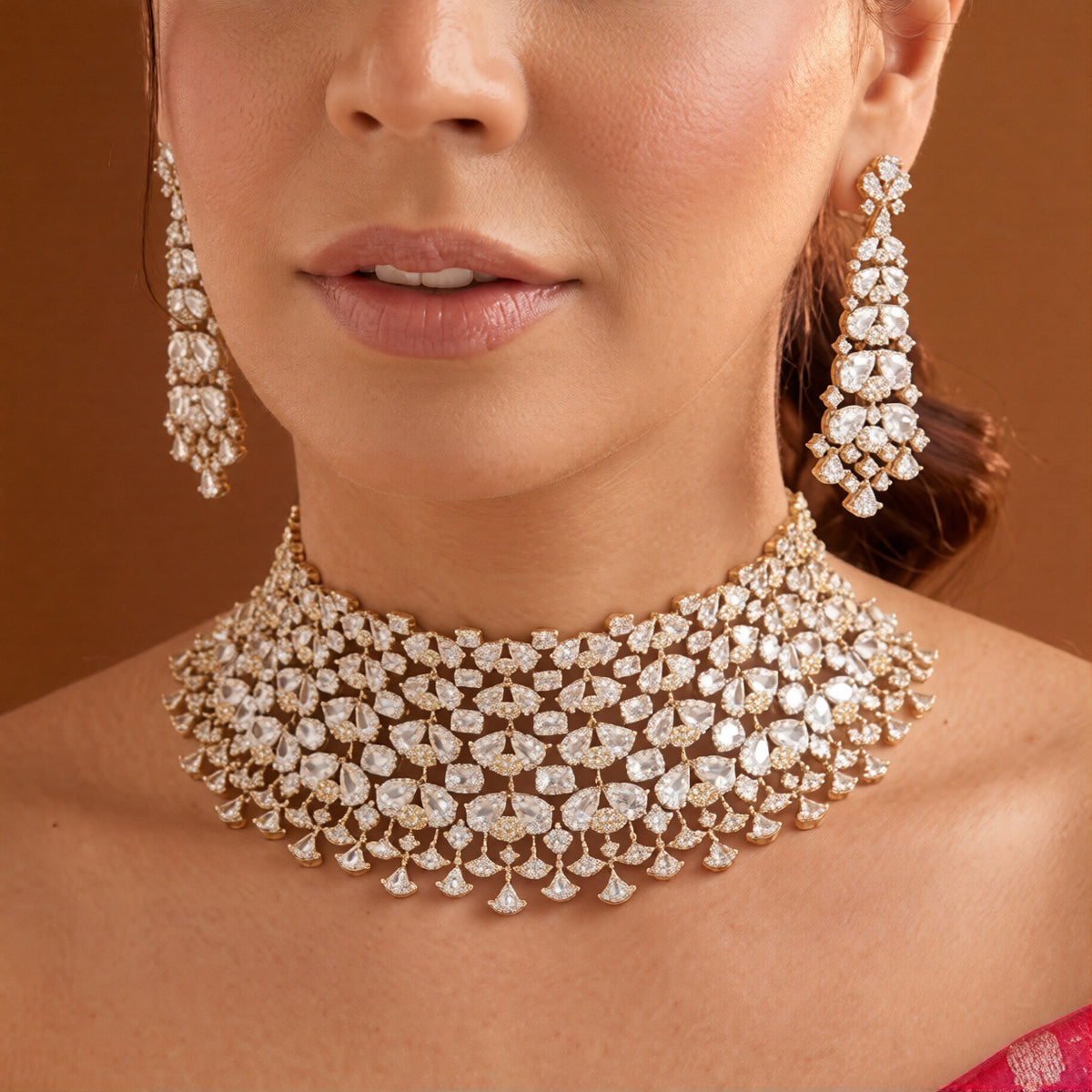 Gold finish American diamond bridal choker necklace on a display bust with a matching long drop earring in hand
