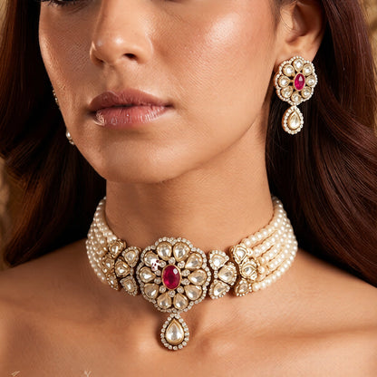 Gold-plated kundan pearl choker necklace set with five white pearl strands, ruby-pink floral centre medallion, teardrop pendant and matching stud earrings