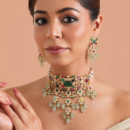 Gold-finish multicolour kundan polki jadau choker necklace set with emerald centre stone, seed pearl strands, lotus drops and matching stud earrings