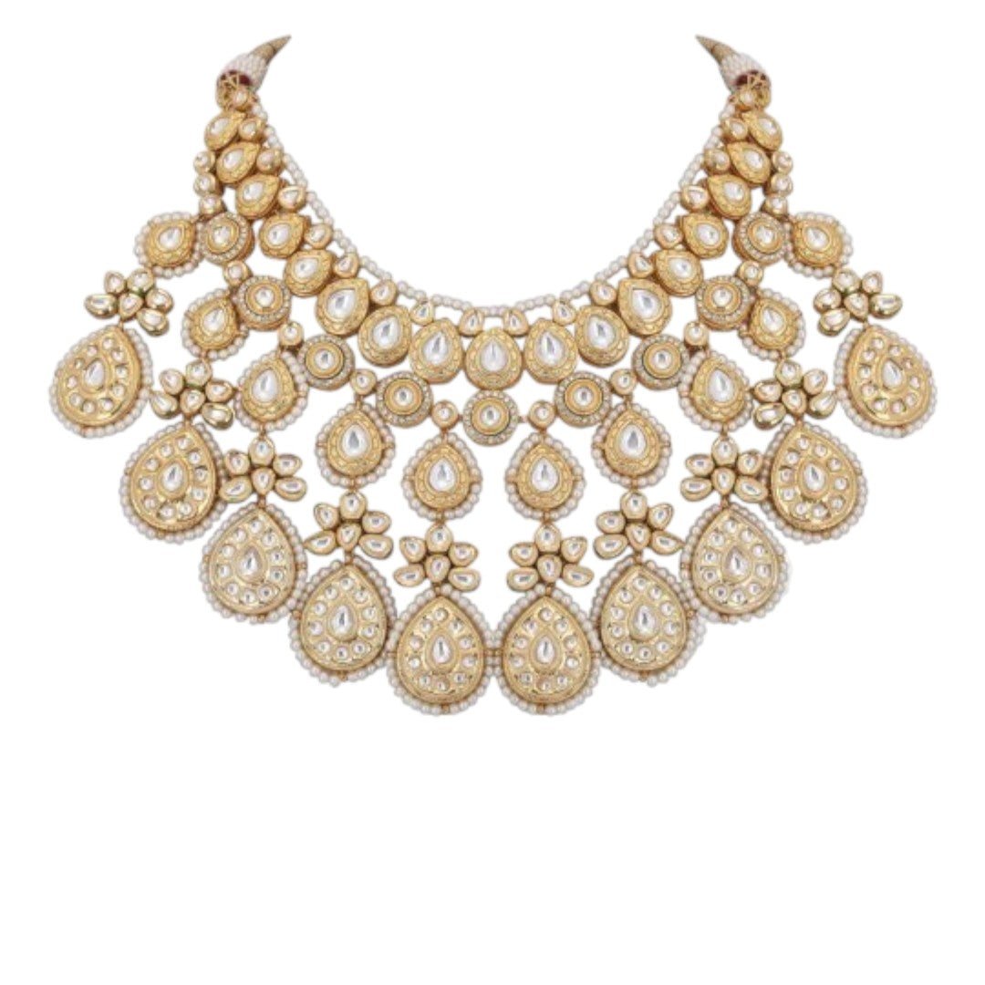 Gold-toned bridal kundan necklace set with pearl edging, maang tikka, and matching jhumka earrings