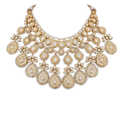 Gold-toned bridal kundan necklace set with pearl edging, maang tikka, and matching jhumka earrings