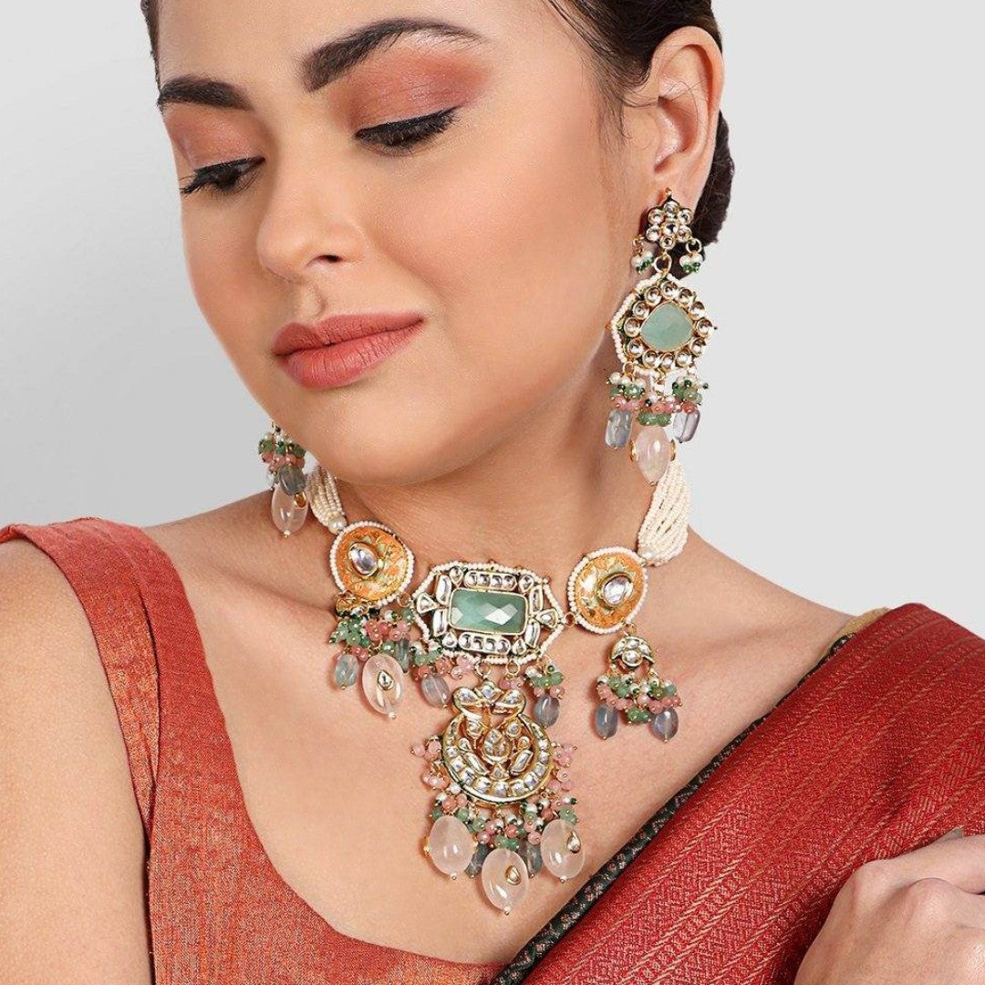 Gold-tone kundan choker necklace with mint green stone, peach meenakari discs and pastel bead drops, shown with matching chandelier earrings