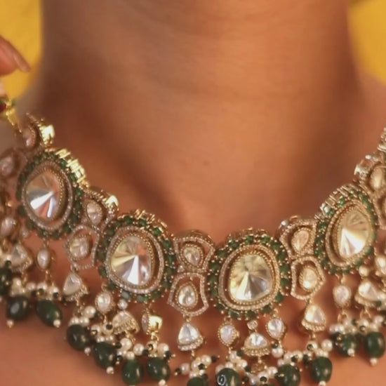 Elegant gold-tone choker necklace set with large mirror-polished stones, green bead accents, and pearl detailing, paired with matching dangling earrings