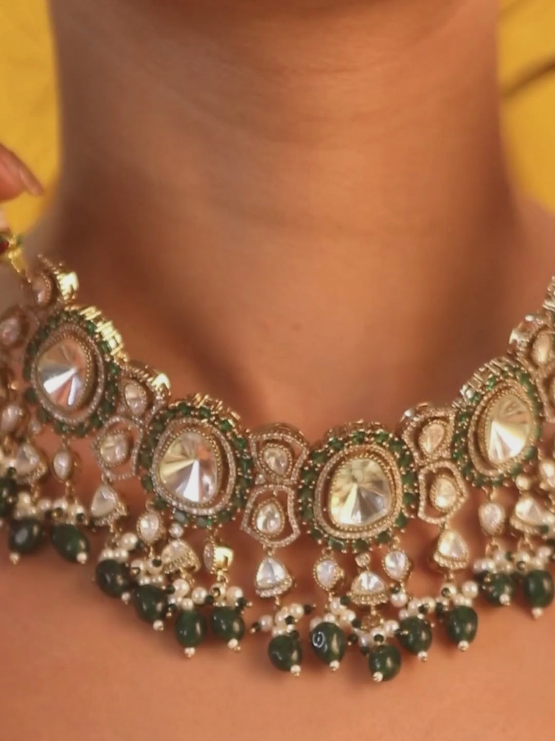 Elegant gold-tone choker necklace set with large mirror-polished stones, green bead accents, and pearl detailing, paired with matching dangling earrings