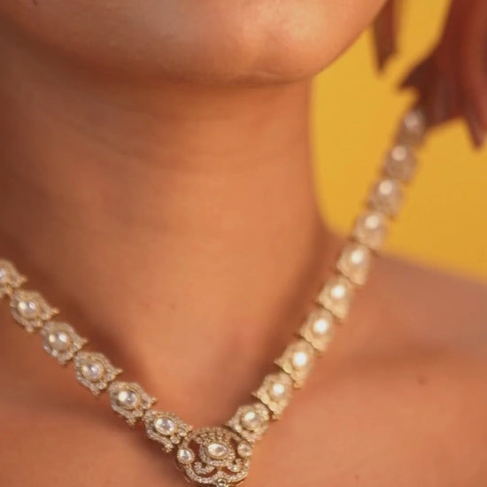 Gold-plated necklace set with peach teardrop pendant and matching statement earrings for bridal and festive wear