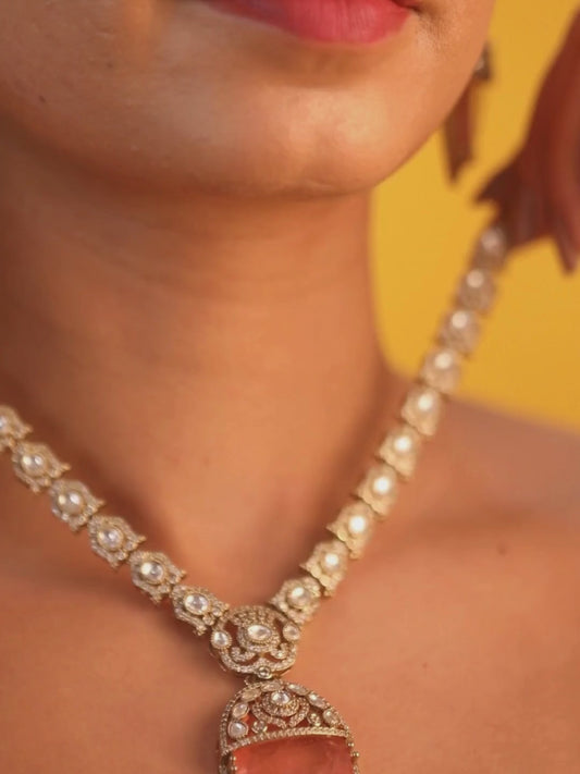 Gold-plated necklace set with peach teardrop pendant and matching statement earrings for bridal and festive wear